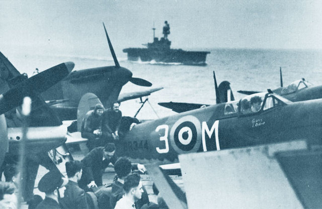 Supermarine Spitfire Mk VC a bordo del USS Wasp.Al fondo, el veterano HMS Eagle le sigue durante su aproximación al punto de lanzamiento
