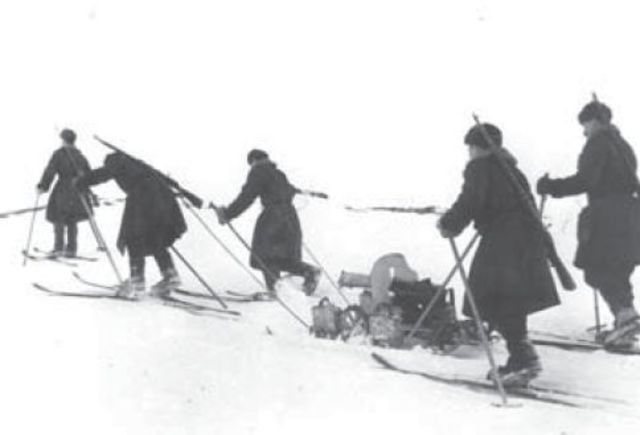 Esquiadores soviéticos se mueven rápidamente en la nieve tirando de una ametralladora Maxim