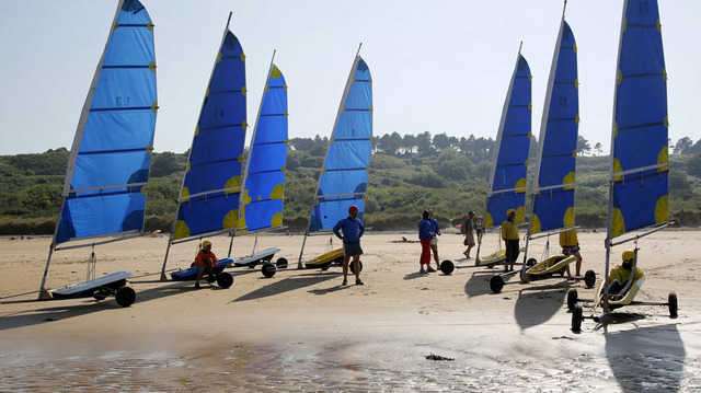 Los turistas participan de una clase de windsurf en la antigua zona de desembarco del Día D, en la playa Omaha