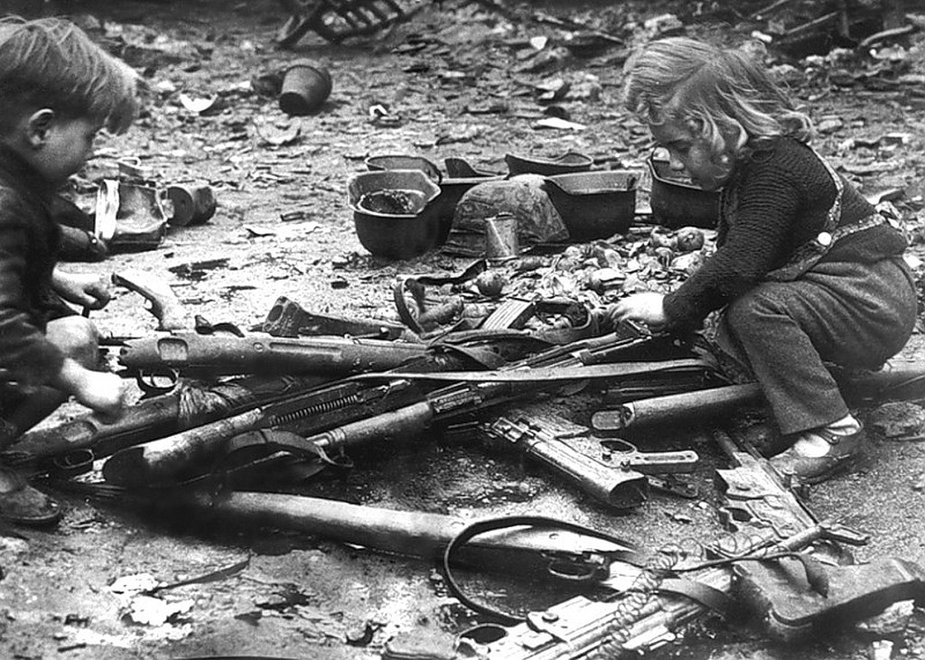 Niños jugando con distintas armas abandonadas en las calles de Berlín