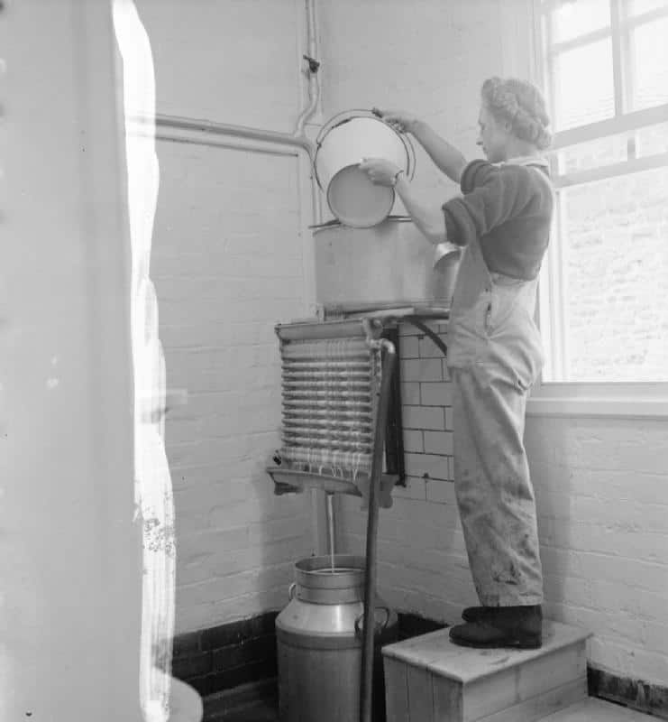 Una estudiante de Land Army opera el enfriador de leche y el separador como parte de su entrenamiento en el Instituto de Agricultura de Northampton, 1942